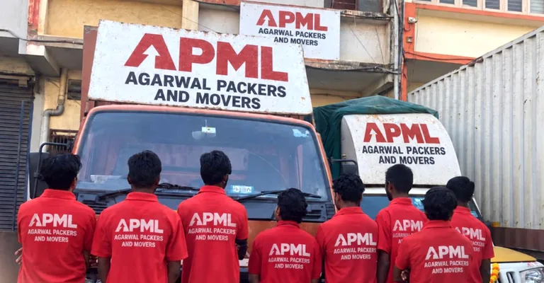 APML professional moving team in red uniforms standing in front of branded truck